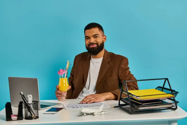 Um homem está imerso no trabalho, sentado em uma mesa com um laptop aberto na frente dele. Ele está focado e concentrado na tarefa em mãos. — Fotografia de Stock