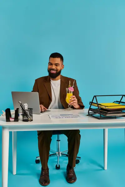 Un homme assis à une table, accroupi dans son écran d'ordinateur portable, à côté d'un verre, profondément dans la pensée et la contemplation. — Photo de stock