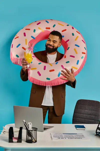 Un homme tient ludique un donut géant devant son visage, créant une scène fantaisiste et humoristique. — Photo de stock