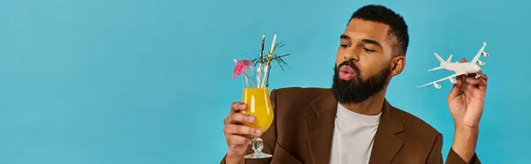 Un uomo tiene un vibrante bicchiere di succo d'arancia appena spremuto, mostrando le qualità rinfrescanti ed energizzanti della bevanda.. — Foto stock