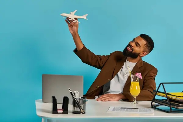 Un uomo è seduto a una scrivania, assorto nel montaggio di un aeroplano modello dettagliato, tenendo con attenzione i pezzi con attenzione e precisione. — Foto stock