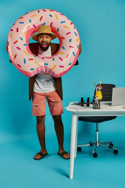 Un homme tient ludique un donut colossal devant son visage, créant une scène fantaisiste et surréaliste. — Photo de stock