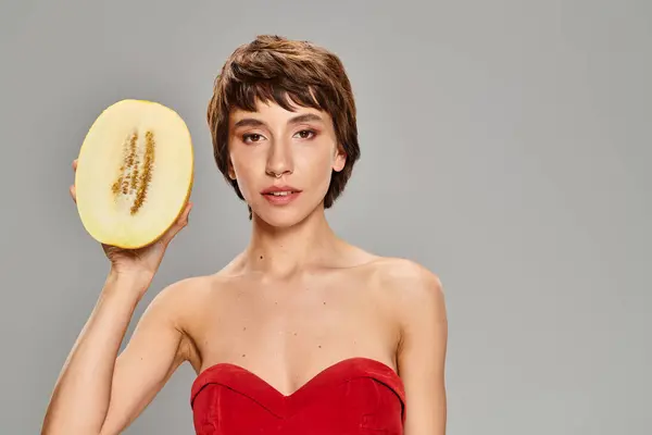 A woman in a red dress holding melon. — Stock Photo