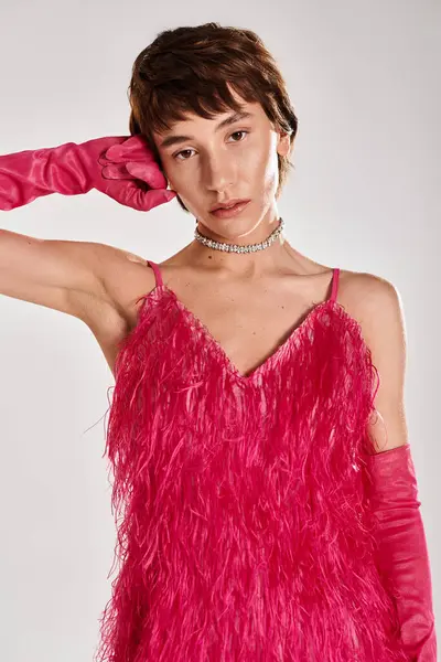 Модная молодая женщина позирует в элегантном розовом платье и перчатках на ярком фоне. — стоковое фото