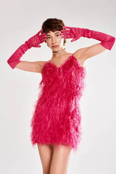 Mujer joven con estilo posa con gracia en un vestido de plumas rojo vibrante. - foto de stock