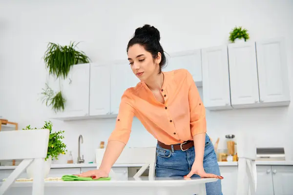 A woman in casual attire rhythmically ironing clothes on an ironing board in a cozy home setting. — Stock Photo