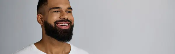 A bearded man in white, smiling warmly. — Stock Photo