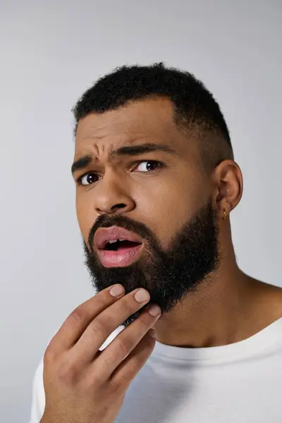 Afro americano sorprendido hombre con una barba cuidando de su pelo. - foto de stock