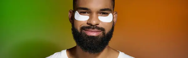 Africain américain bel homme utilisant des patchs pour les yeux. — Photo de stock