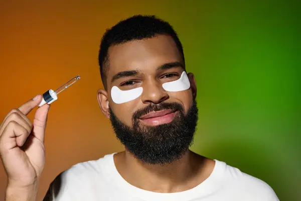 African american young man using eye patches and serum. — Stock Photo