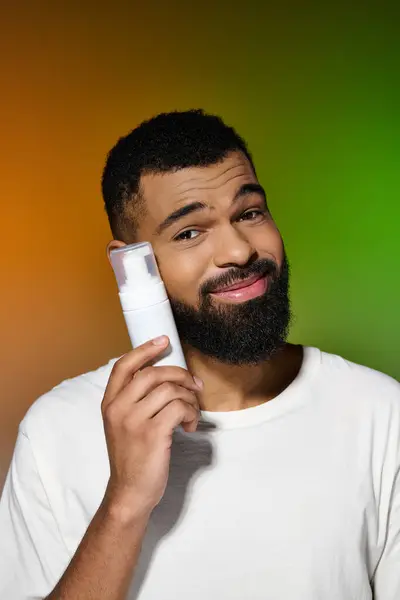 Africano americano guapo hombre sostiene afeitar crema. - foto de stock