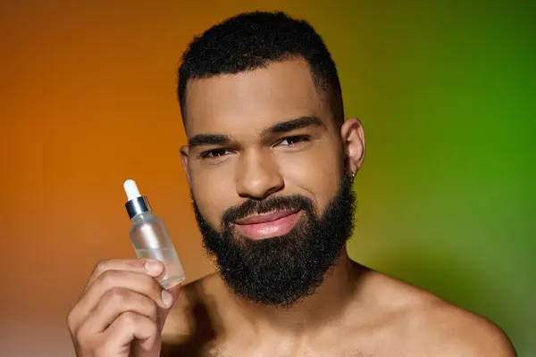 Afroamerikaner mit Bart hält Serum in der Hand. — Stockfoto