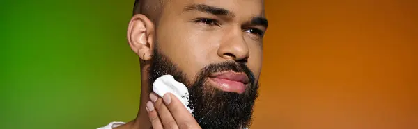 Afroamericano attraente uomo utilizzando la crema da barba. — Foto stock