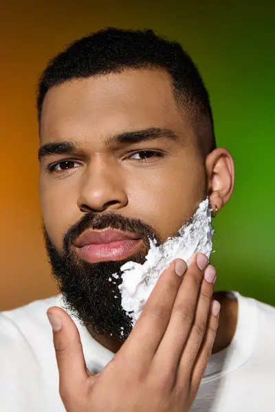 Young man closely shaves his face as part of a skincare routine. — Stock Photo