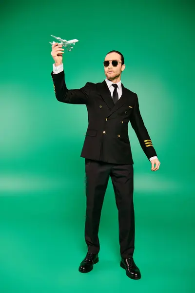 Stylish man in suit and sunglasses, holding a model airplane. — Stock Photo