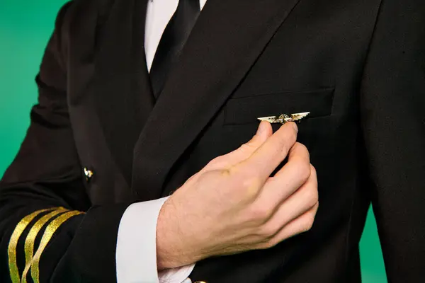 Ein Pilot im scharfen Anzug und Krawatte steht selbstbewusst vor grünem Hintergrund. — Stockfoto