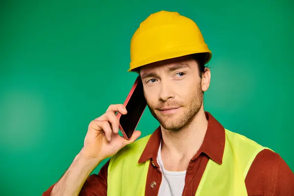 Ein Mann mit harter Mütze spricht auf seinem Handy. — Stockfoto