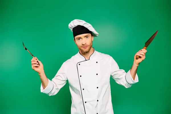 Bello chef maschio in abito bianco con fiducia in possesso di posate. — Foto stock