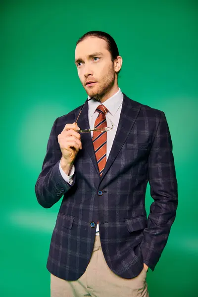 A stylish businessman in a chic suit and tie confidently holding glasses. — Stock Photo