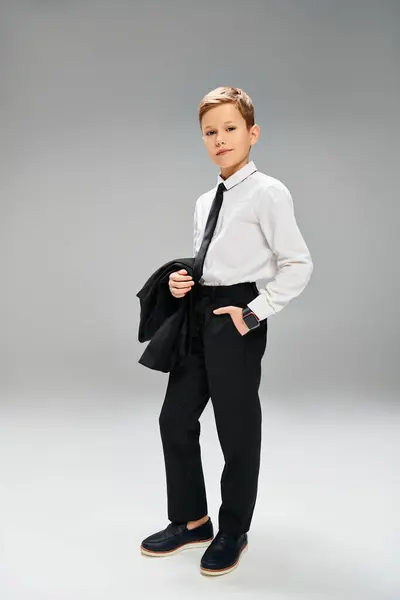Elegant preadolescent boy in a white shirt and black tie against a gray backdrop. — Stock Photo