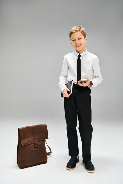 Ragazzo preadolescente si leva in piedi dalla valigetta in abbigliamento elegante. — Foto stock