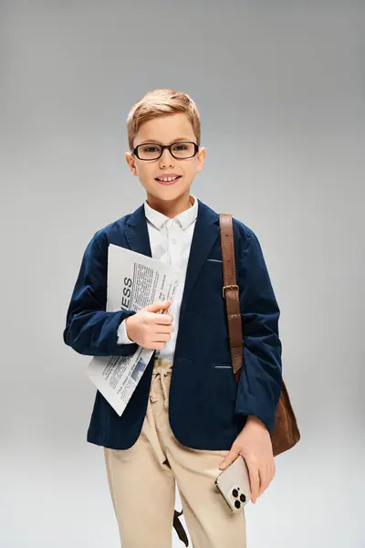 A young boy in glasses and a blue blazer exuding elegance on a gray backdrop. — Stock Photo
