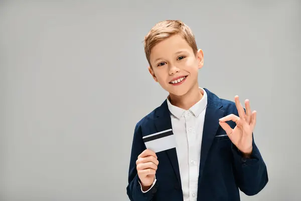 Elegante menino segurando um cartão e fazendo um sinal de paz. — Fotografia de Stock