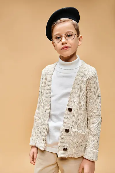 Jeune garçon avec lunettes et chapeau, imitant un réalisateur, sur fond beige. — Photo de stock