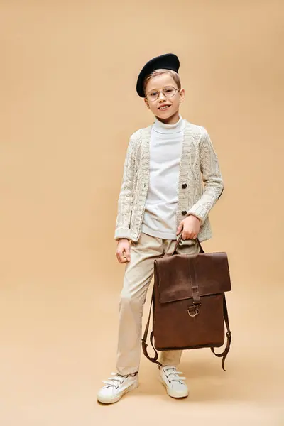 Preadolescent boy dressed as film director holds a brown briefcase. — Stock Photo