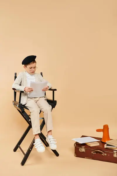 Niño sentado, profundamente absorto en la lectura de un pedazo de papel. - foto de stock