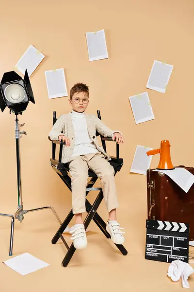 Young boy dressed as a film director sitting in a chair, ready for action. — Stock Photo