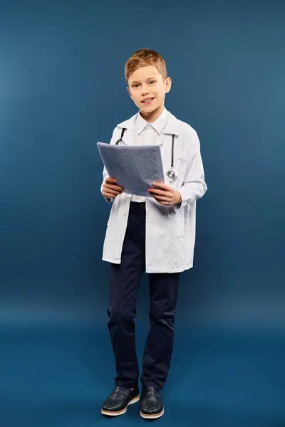 Um rapaz curioso com um casaco de laboratório inspeciona cuidadosamente a sua área de transferência.. — Fotografia de Stock