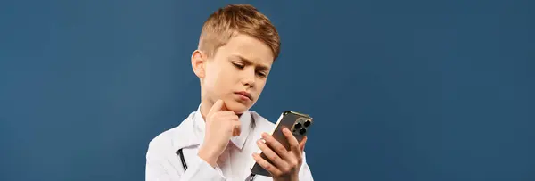 Joven niño absorto en la pantalla del teléfono celular. - foto de stock