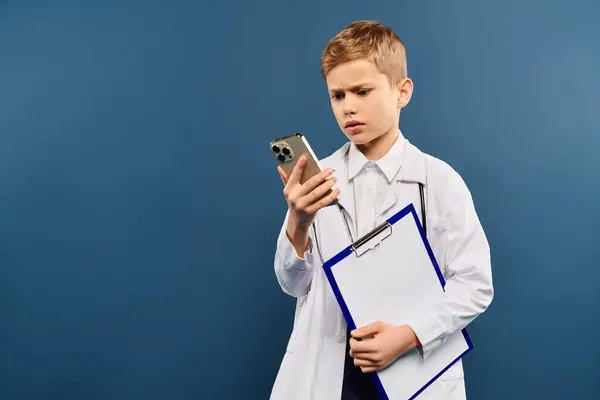 Un ragazzino, con in mano una cartellina e un cellulare. — Foto stock