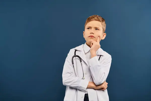 Giovane ragazzo in cappotto bianco e stetoscopio su sfondo blu. — Foto stock