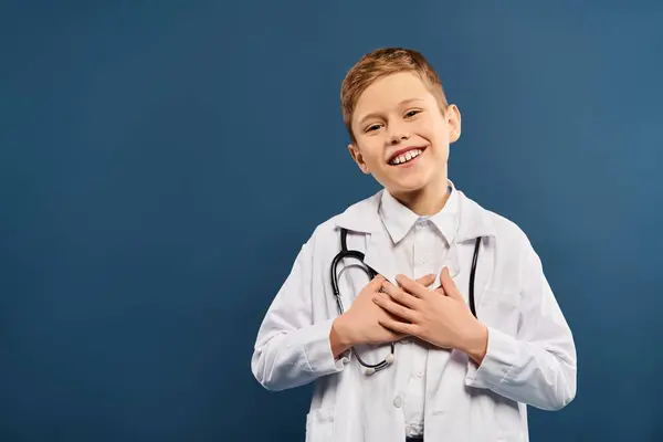 Giovane ragazzo in cappotto medici e stetoscopio su sfondo blu. — Foto stock