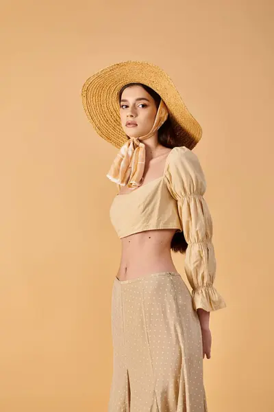 Une jeune femme aux longs cheveux bruns rayonne d'une ambiance estivale dans un chapeau et une robe de paille, exsudant élégance et grâce. — Photo de stock