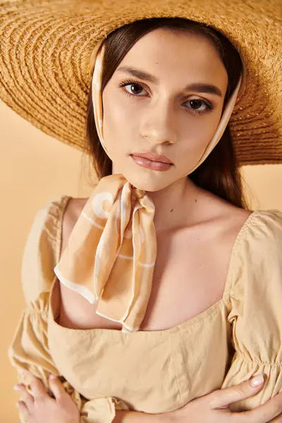 Uma jovem com longos cabelos morena marcando uma pose em uma roupa de verão, exalando uma vibe quente e de verão com um grande chapéu de palha. — Fotografia de Stock
