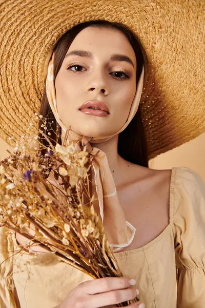 Молода брюнетка викриває літо, коли вона тримає букет барвистих квітів у стильному солом'яному капелюсі. — стокове фото
