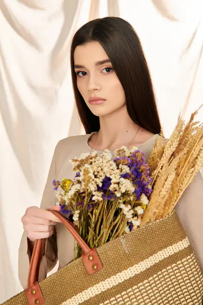 Uma jovem com cabelos longos e morena em uma roupa de verão segura um saco cheio de flores vibrantes, exalando uma vibração alegre. — Fotografia de Stock