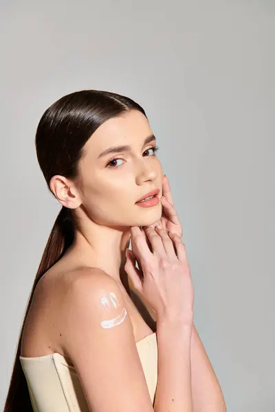 Eine junge Frau mit brünetten Haaren präsentiert ihre Haut in einem intimen Studio-Rahmen als einzigartig und schön. — Stockfoto