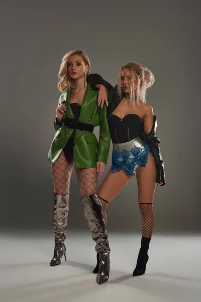 Дві спокусливі жінки в витончених костюмах вражають позу разом, виключаючи таємницю і привабливість. — стокове фото