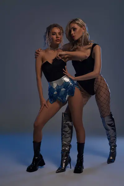 Duas mulheres jovens sexy em shorts curtos e botas marcando uma pose para a câmera. — Fotografia de Stock