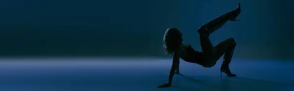 A woman effortlessly performs a handstand in the dark, showcasing grace and strength in a stunning pose. — Stock Photo
