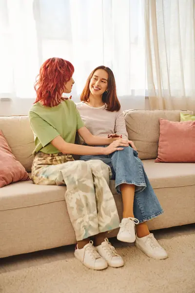 Lgbt couple sharing a tender moment on a cozy sofa in living room, two young lesbian women — Stock Photo