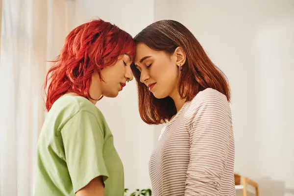 Serene young lesbian couple with closed eyes standing next to each other at home, bliss and love — Stock Photo