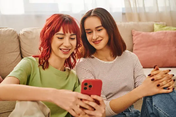 Молода лесбіянка пара посміхається і використовує смартфон разом, сучасний спосіб життя і зв'язок — стокове фото