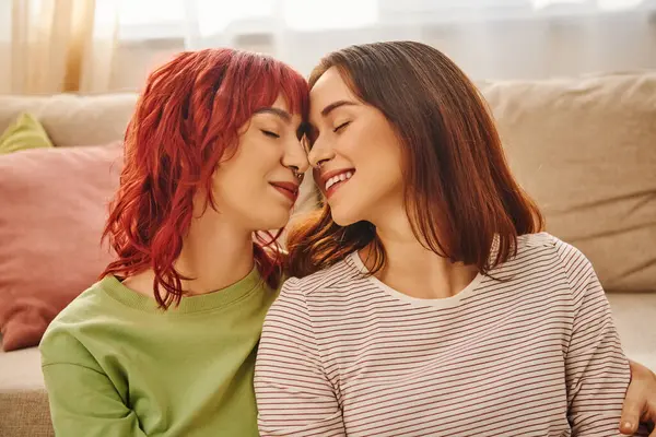 Serene moment of happy lesbian couple with closed eyes smiling at home, bliss and love — Stock Photo