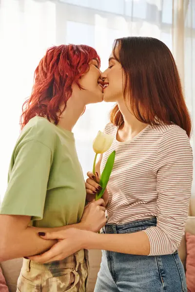 Tender moment of lesbian couple with closed eyes kissing near blooming tulip, symbol of spring — Stock Photo