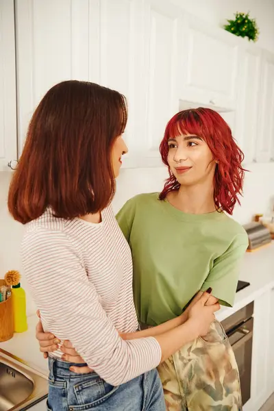 Intimate kitchen scene with a happy young lesbian couple sharing a moment of connection, embrace — Stock Photo